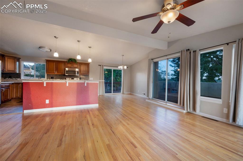 Image 11 of 43: Kitchen featuring a kitchen breakfast bar, backsplash, brown cabinetry, han