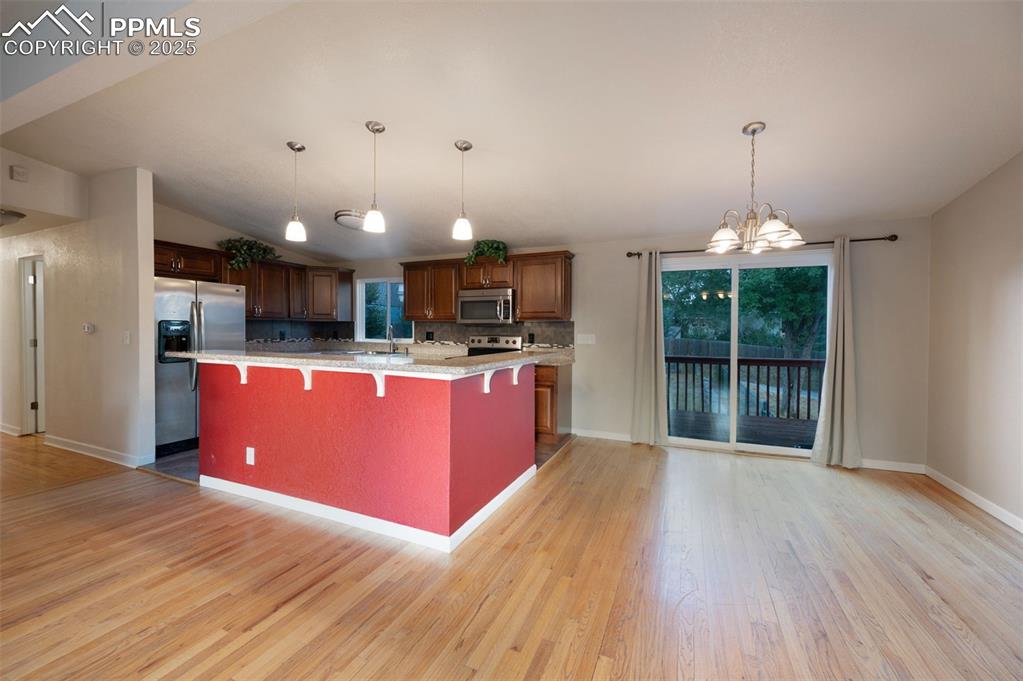 Image 13 of 43: Kitchen featuring a chandelier, appliances with stainless steel finishes, a