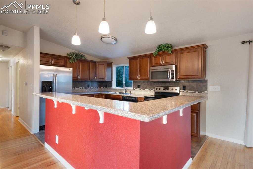 Image 14 of 43: Kitchen featuring backsplash, stainless steel appliances, light wood-style 