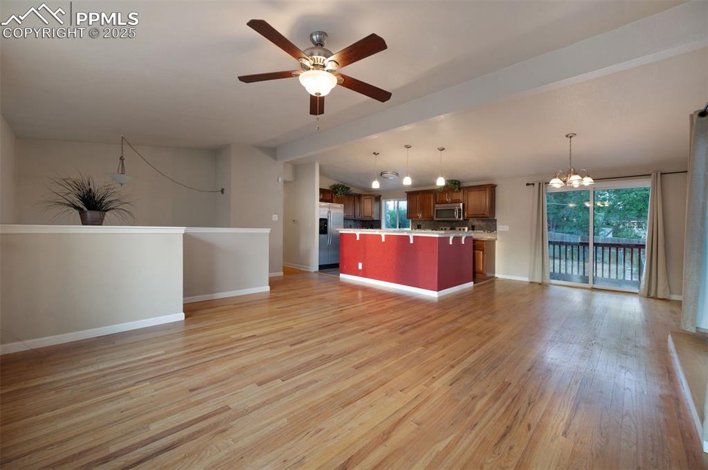 Image 9 of 43: Unfurnished living room featuring a chandelier, lofted ceiling, healthy amo
