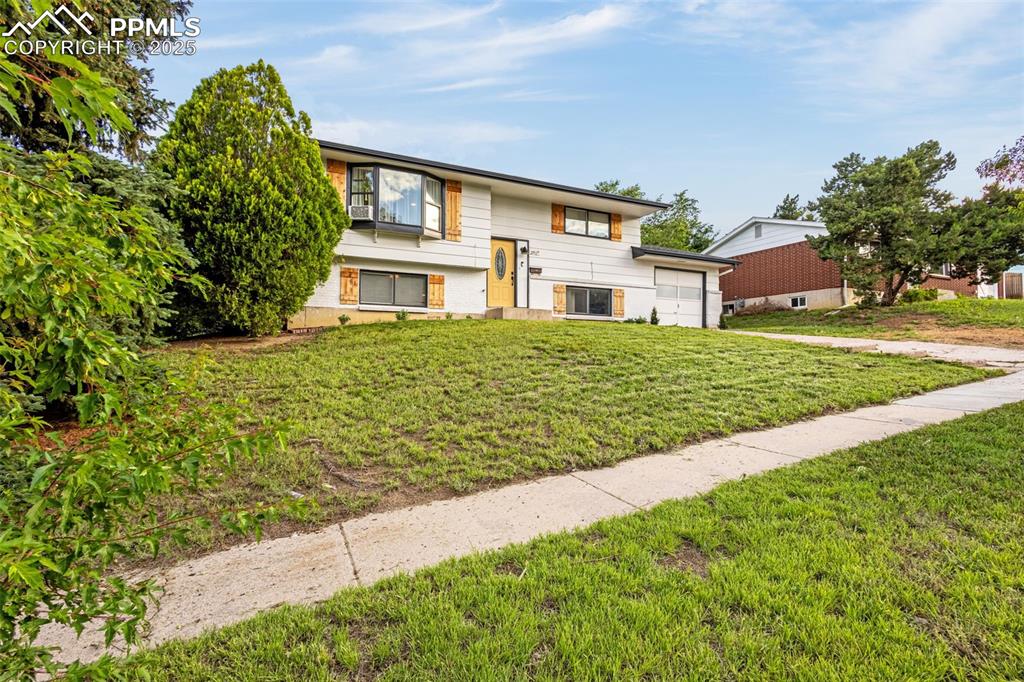 Image 2 of 32: Raised ranch featuring a front lawn and an attached garage