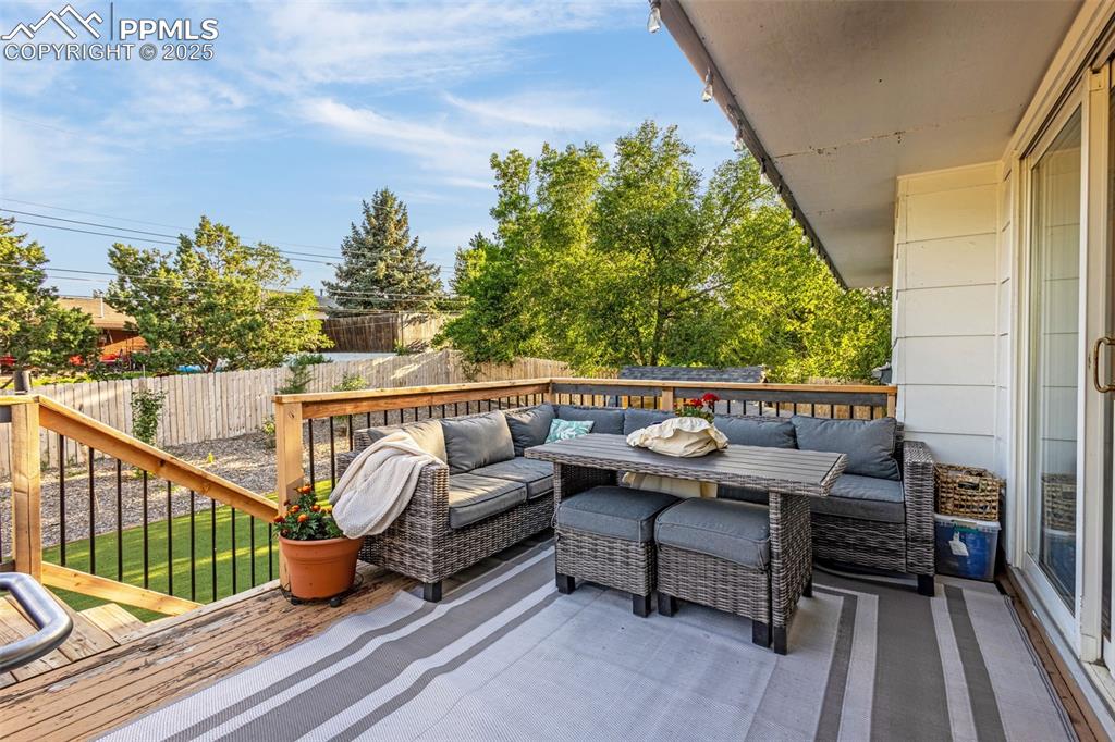 Image 23 of 32: Wooden deck with an outdoor living space and a fenced backyard