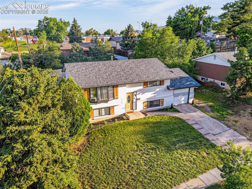 Image 26 of 32: View of front of house featuring a garage, a front lawn, driveway, and roof
