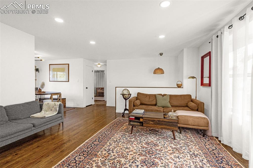 Image 7 of 32: Living area with wood finished floors and recessed lighting