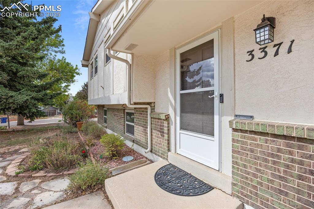 Image 17 of 50: Property entrance featuring stucco siding and brick siding