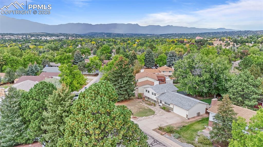 Image 44 of 50: Aerial view of residential area featuring a mountainous background