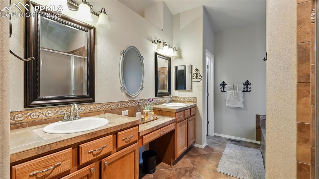 Image 10 of 50: Luxurious 5-pc Bath with a dual-head, custom-tiled shower, soaking tub, dua