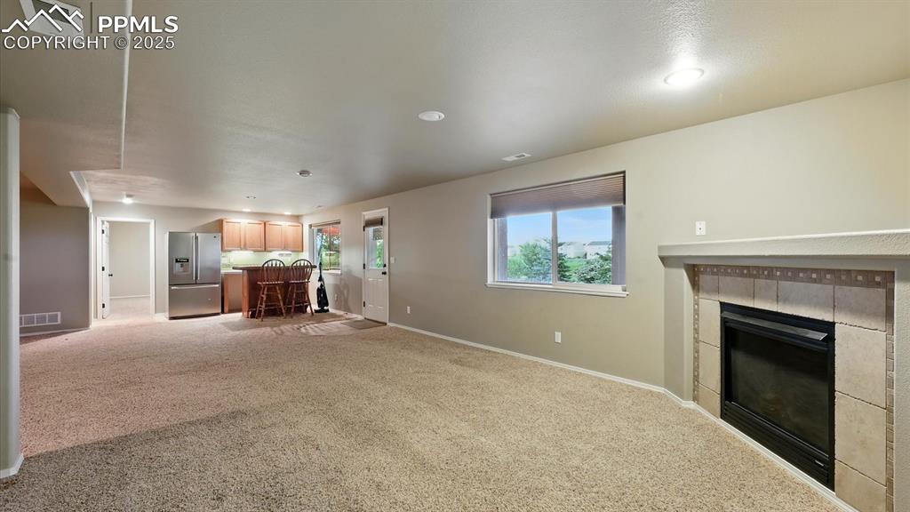 Image 15 of 50: Basement fun zone with Family Room, Wet Bar, and Media Area. Walk out to a 