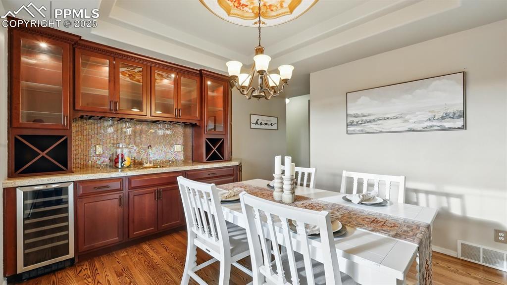 Image 21 of 50: Stunning formal Dining Room with recessed ceiling, modern light fixture, an