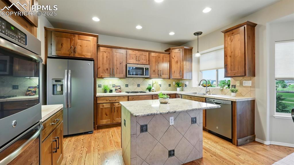 Image 25 of 50: Stainless steel appliances include a dishwasher, side by side refrigerator,