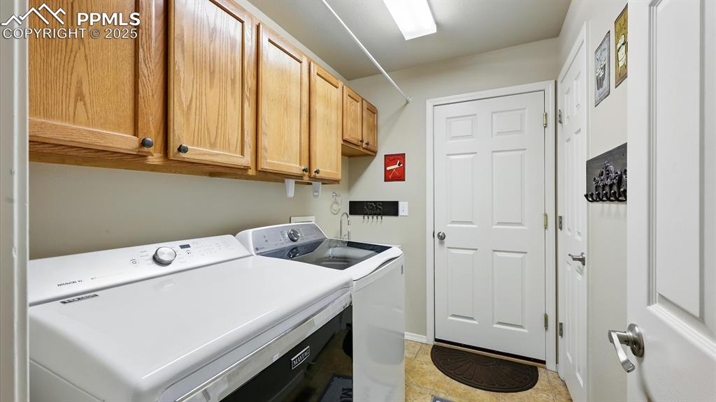 Image 29 of 50: Main Level Laundry Room with upper cabinets and washer/dryer that stays.