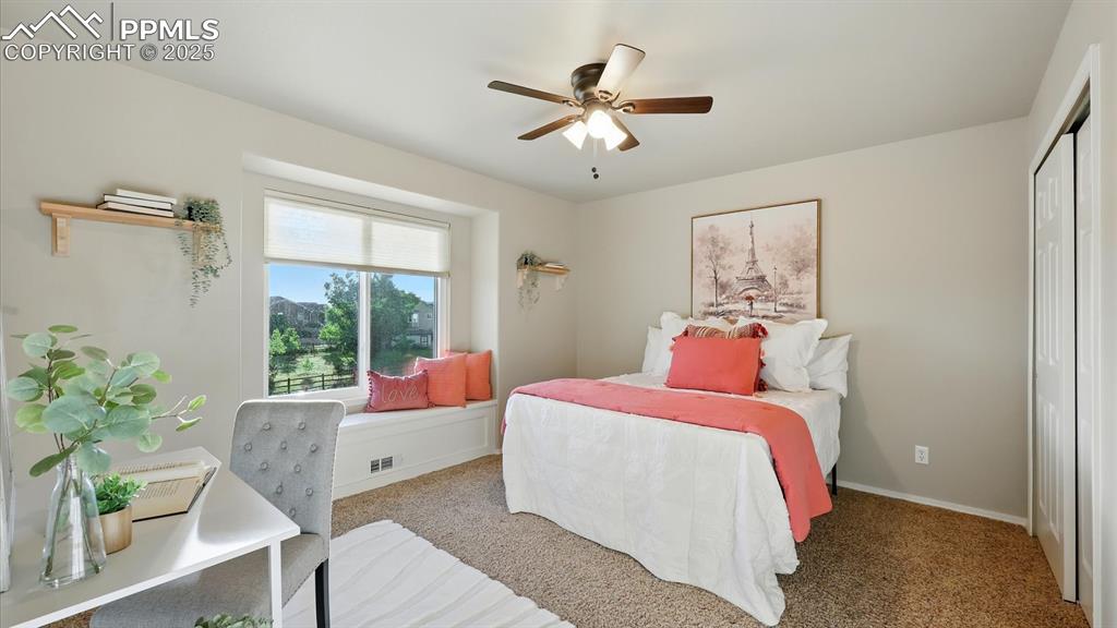 Image 37 of 50: Upper Level Bedroom #2 offers neutral carpet, a lighted ceiling fan, genero