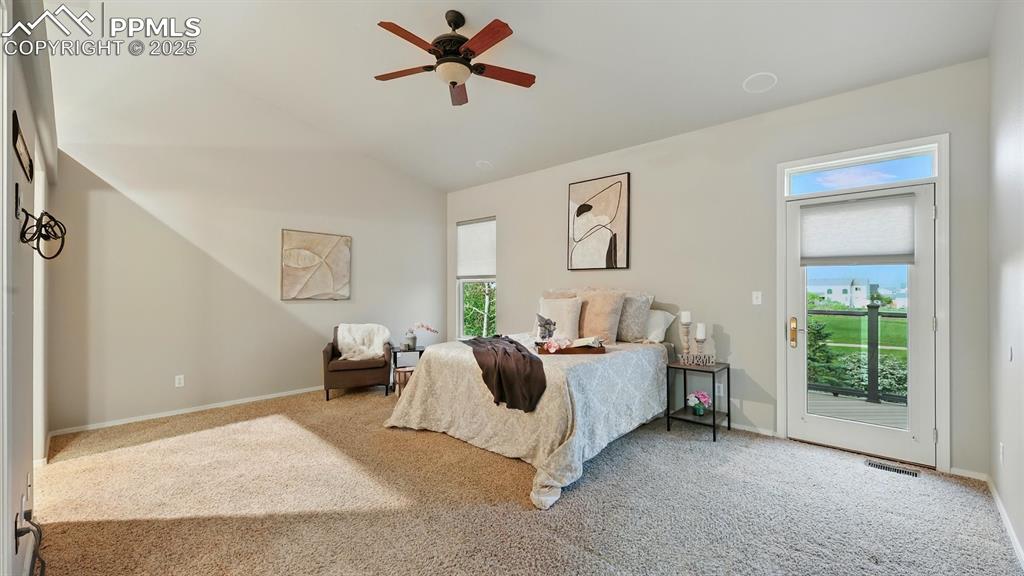 Image 9 of 50: The spacious main-level Primary Suite boasts plush carpeting, direct deck a