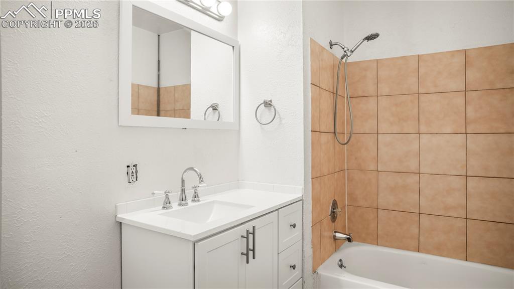 Image 14 of 20: Full bathroom featuring washtub / shower combination, vanity, and a texture