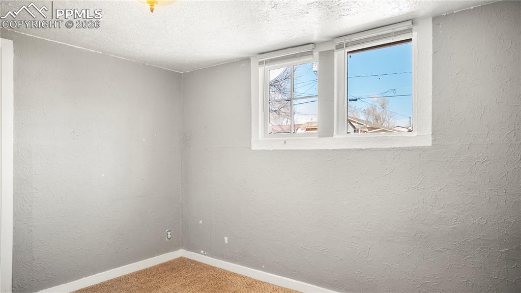 Image 18 of 20: Carpeted empty room with a textured wall and a textured ceiling