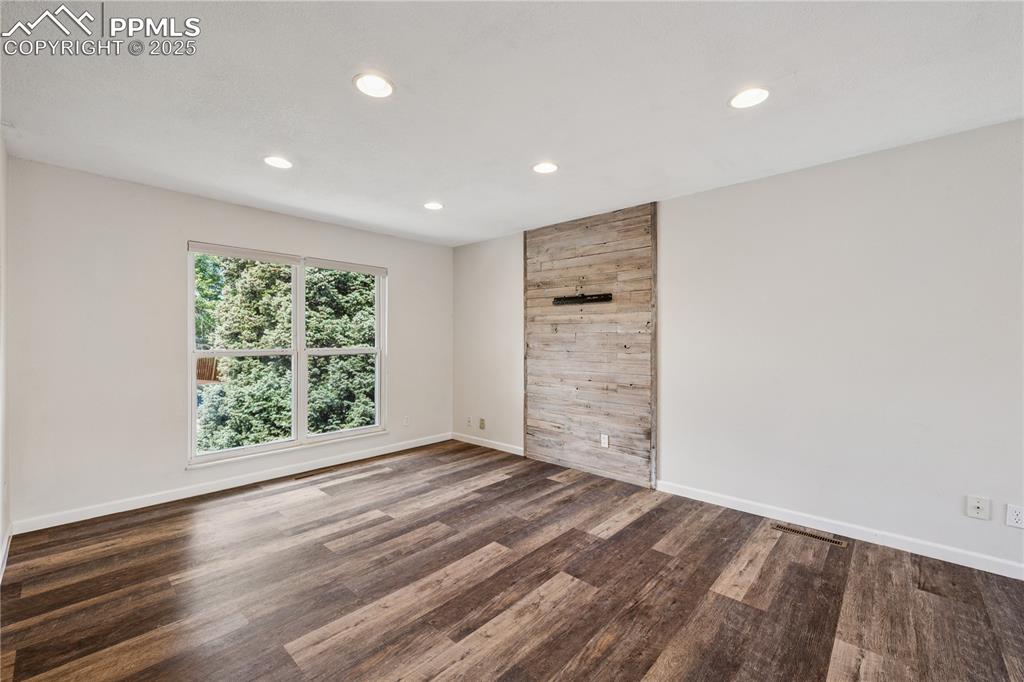 Image 11 of 35: Living room featuring wood style floors and recessed lighting, wall mount f