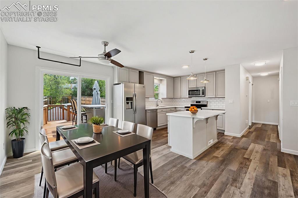 Image 12 of 35: Dining room featuring dark wood finished floors and ceiling fan. Virtually 