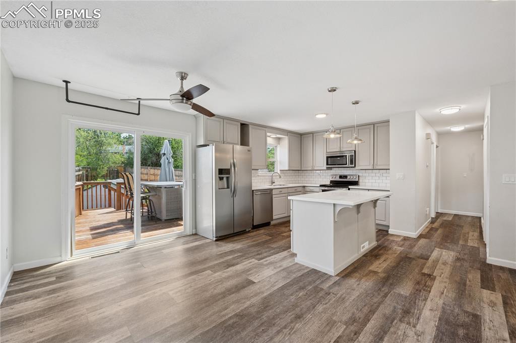 Image 13 of 35: Kitchen featuring appliances with stainless steel finishes, decorative back