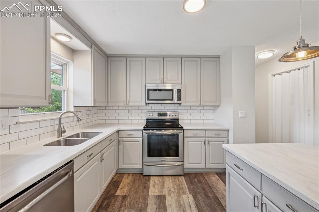 Image 18 of 35: Kitchen featuring appliances with stainless steel finishes, dark wood-style