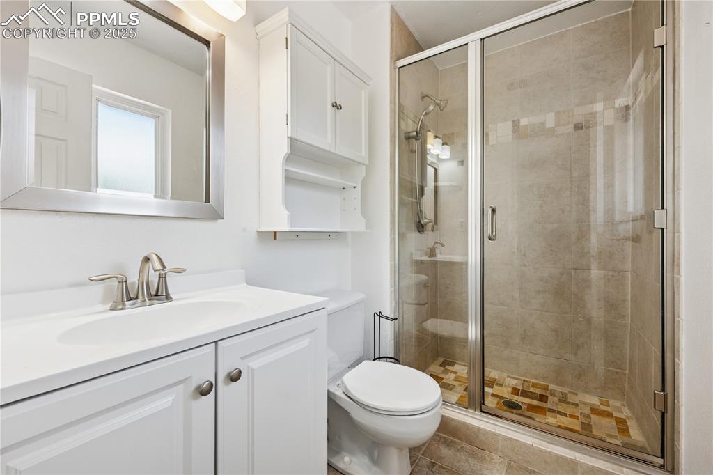 Image 22 of 35: Full bathroom featuring vanity, a shower stall, and light tile patterned fl