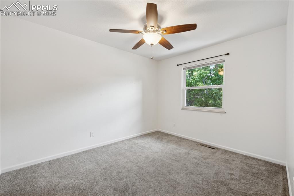 Image 24 of 35: Carpeted bedroom and ceiling fan