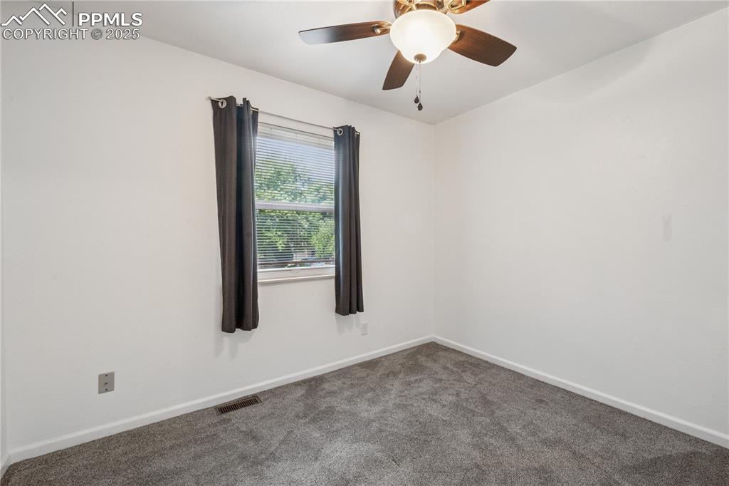 Image 26 of 35: Empty room with carpet floors and ceiling fan