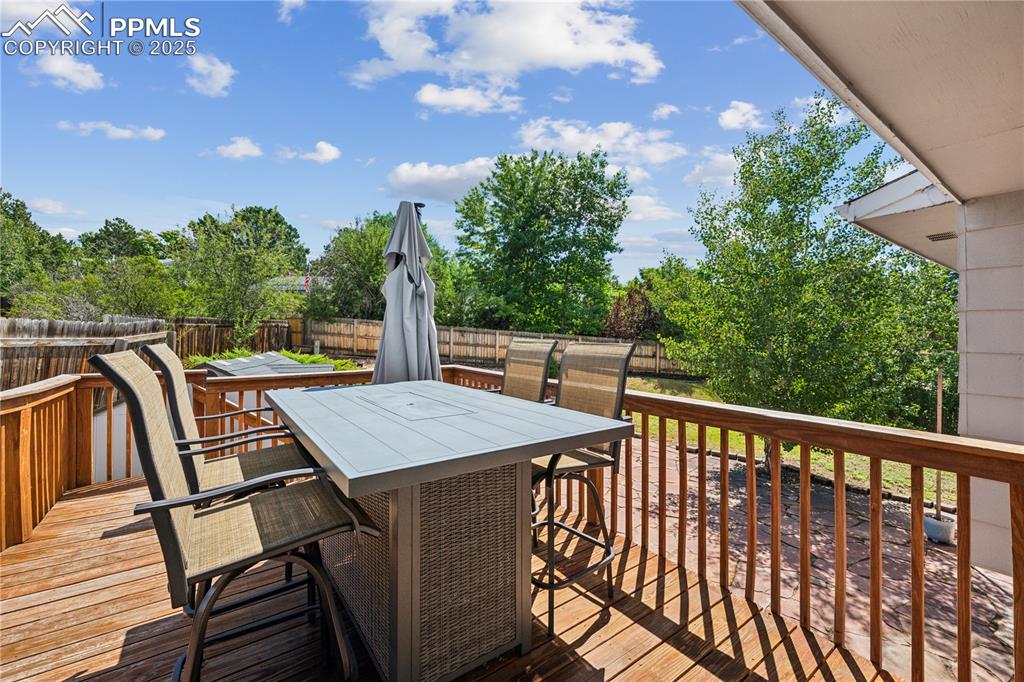 Image 4 of 35: Wooden terrace with outdoor dining space and a fenced backyard