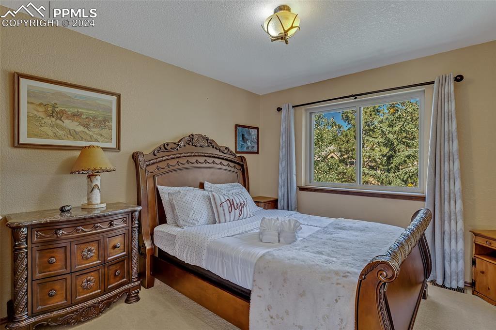 Image 20 of 39: Upper Bedroom, 2nd Bedroom, Wooden Bed, Carpeted Floor,