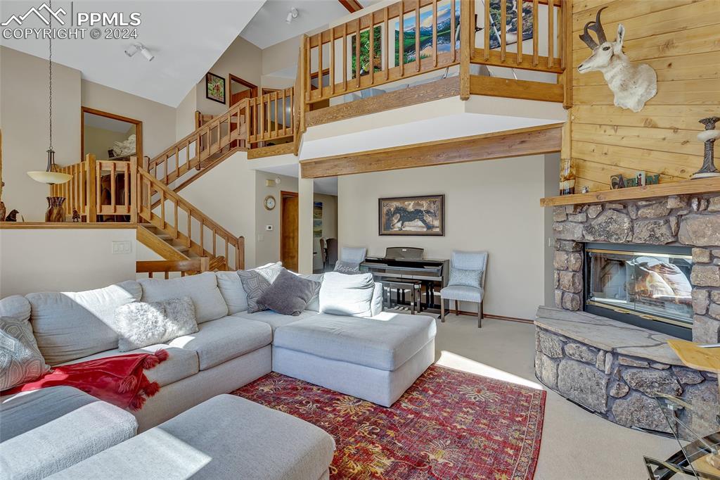 Image 3 of 39: Spacious Living, Piano, Open Living, Wooden Stairs, Carpeted, Floor, Firepl