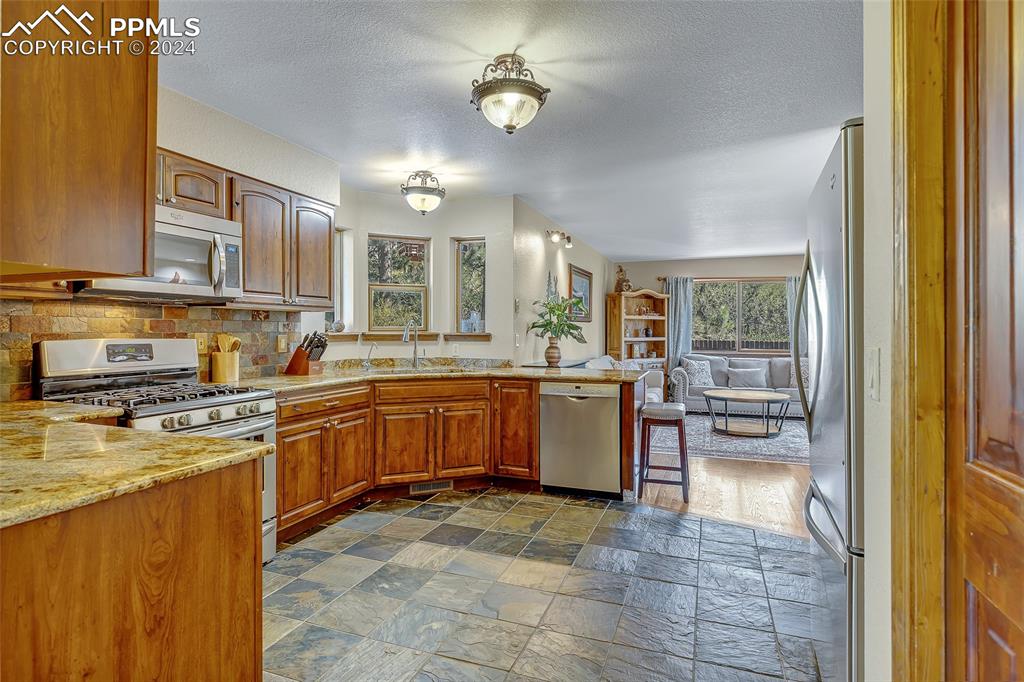 Image 7 of 39: Gorgeous Kitchen, Granite Countertops, Wooden Cabinets, Tile Floor, Attache