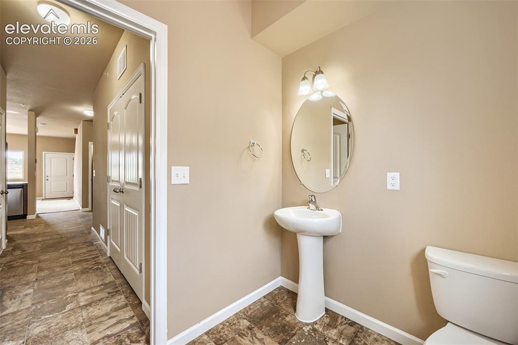 Image 10 of 25: Pedestal sink with an oval mirror and two-light vanity fixture