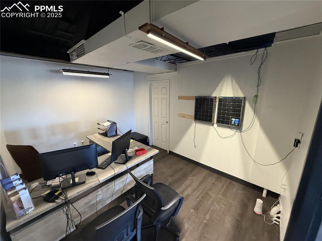 Image 9 of 28: Office area with dark wood-type flooring and baseboards