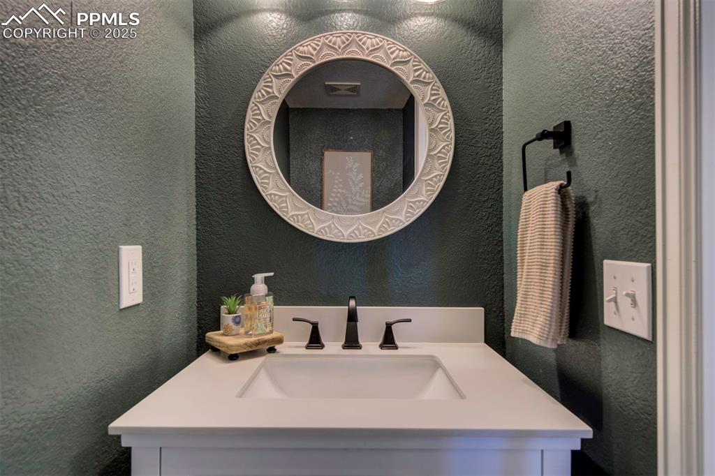 Image 13 of 30: Bathroom featuring a textured wall and vanity