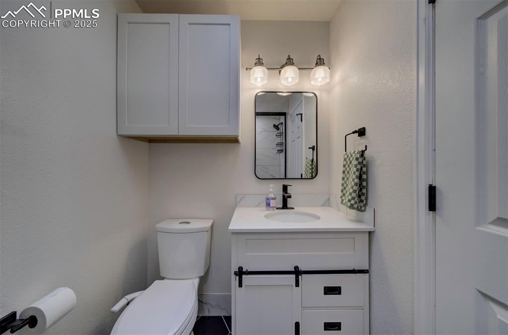 Image 16 of 30: Full bath with vanity and a textured wall
