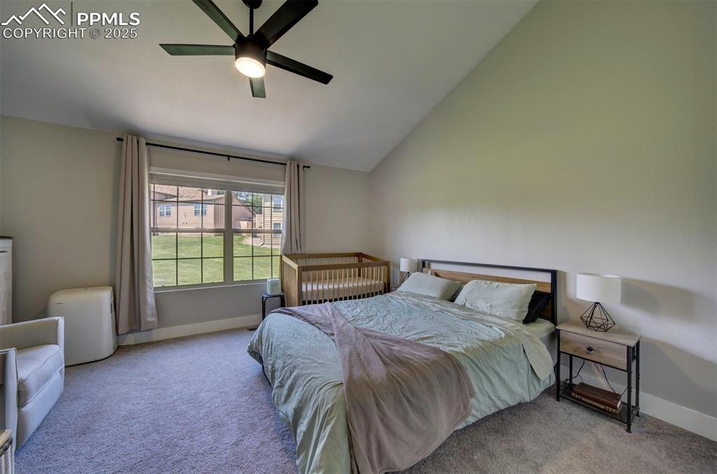 Image 17 of 30: Bedroom with carpet flooring, ceiling fan, and high vaulted ceiling