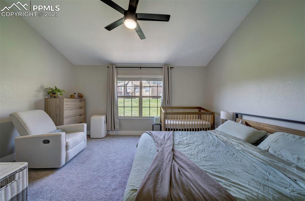 Image 19 of 30: Carpeted bedroom with vaulted ceiling, ceiling fan, and a textured wall