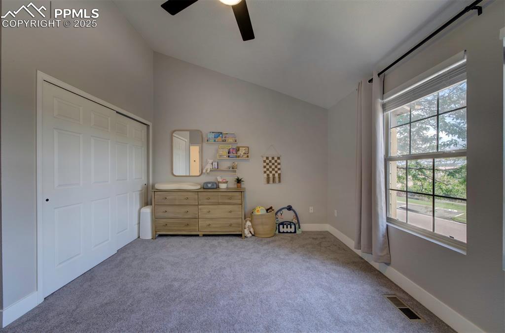 Image 20 of 30: Bedroom with vaulted ceiling, carpet, and a ceiling fan