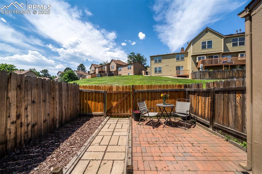 Image 24 of 30: Fenced backyard featuring a residential view, a patio, and outdoor dining s