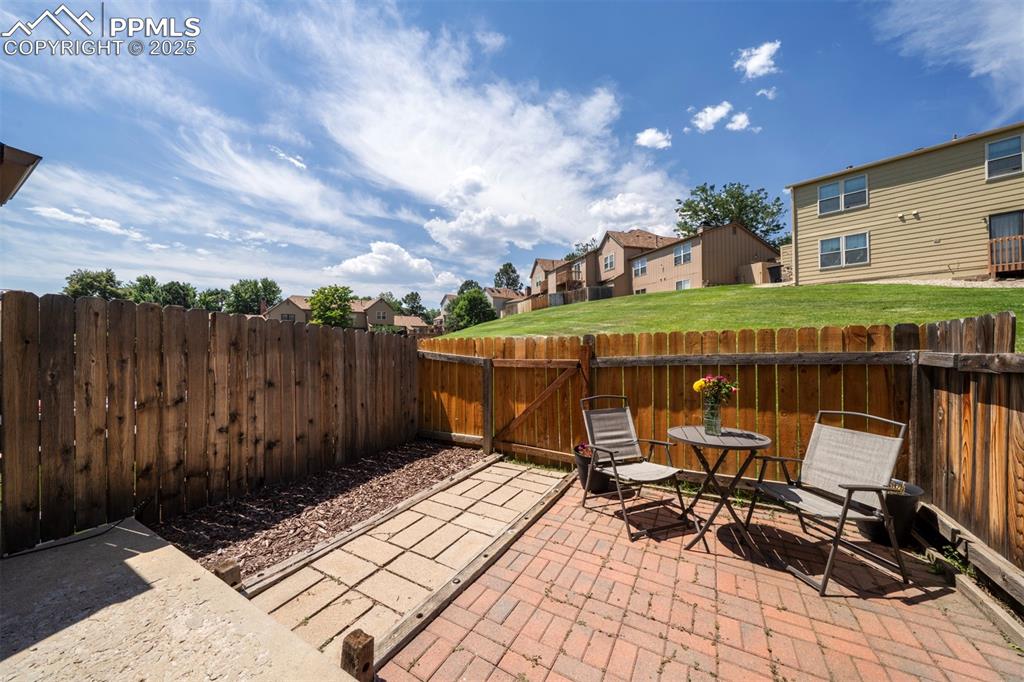 Image 26 of 30: Fenced backyard with a residential view, a patio area, and a gate