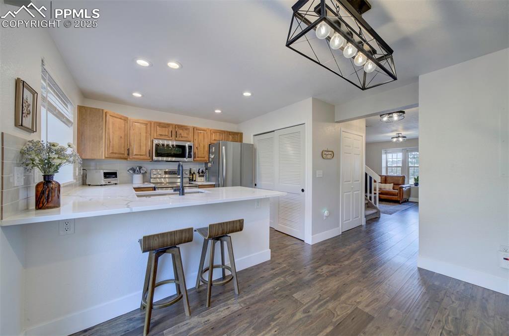 Image 7 of 30: Kitchen with recessed lighting, a breakfast bar, a peninsula, dark wood-typ