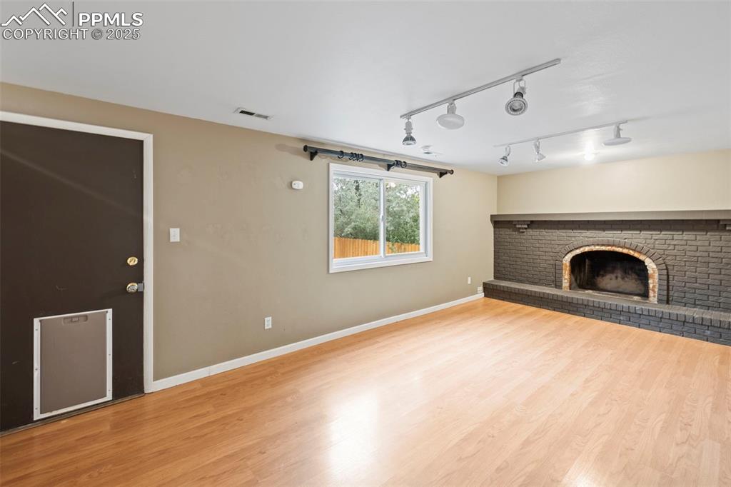 Image 5 of 49: Family room with fireplace. Fireplace will need insert to work.