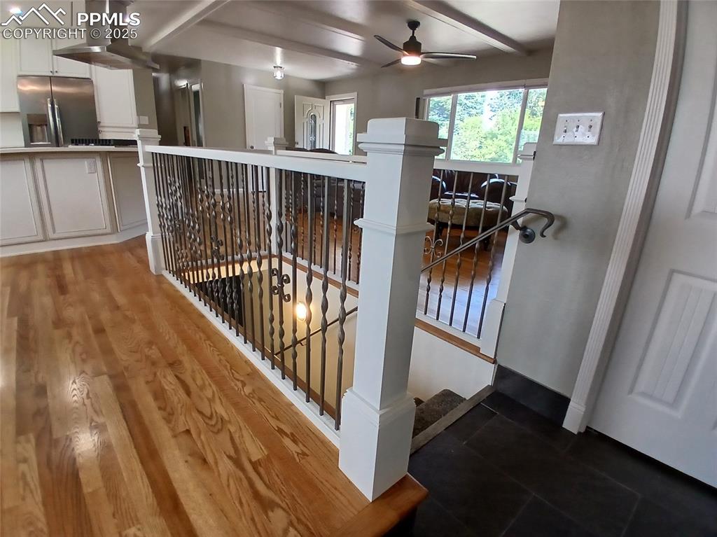 Image 29 of 49: Stairway featuring wood-type flooring, beam ceiling, and ceiling fan