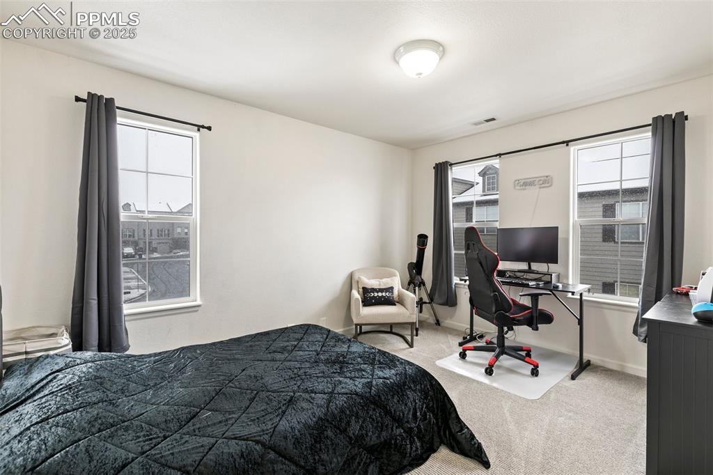 Image 27 of 36: Carpeted bedroom featuring a desk and baseboards