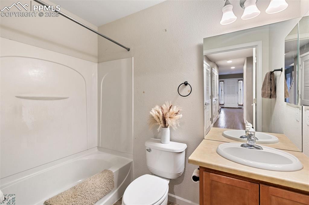 Image 28 of 36: Bathroom featuring bathtub / shower combination, toilet, vanity, and a text