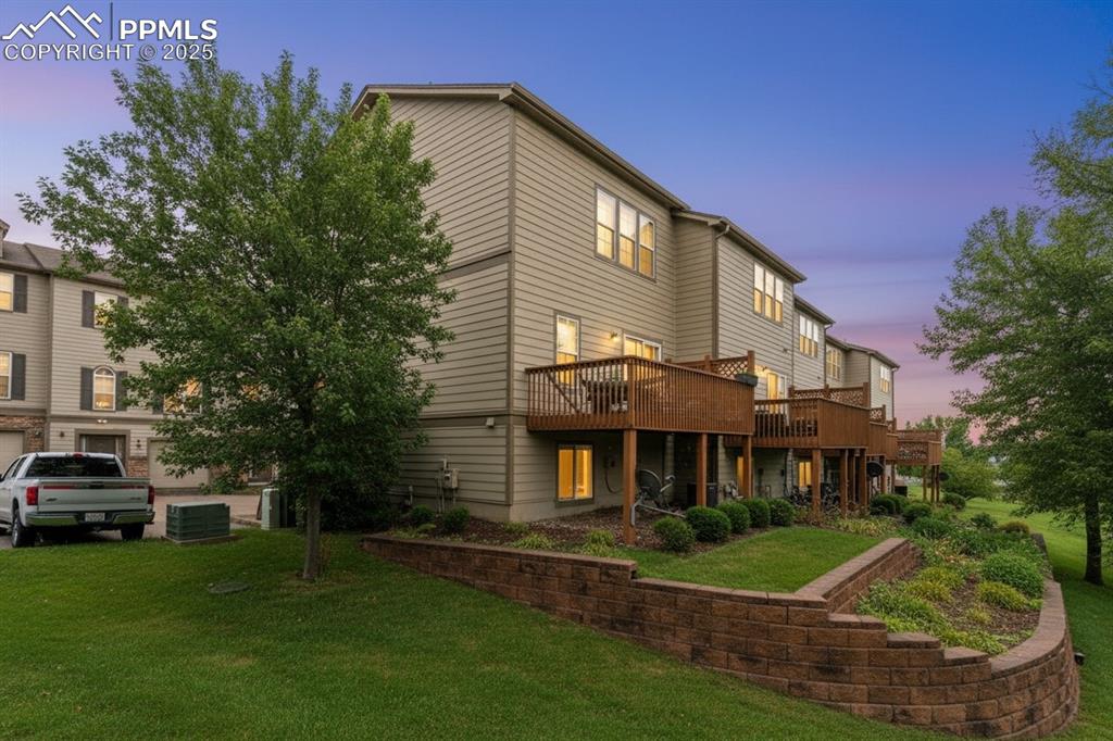 Image 34 of 36: Rear view of house featuring a lawn and a deck