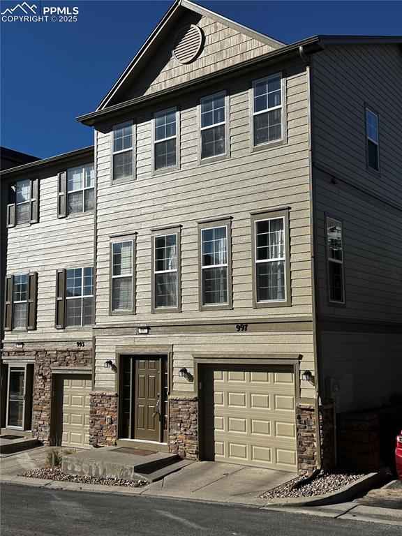 Image 36 of 36: View of front of house featuring an attached garage and stone siding
