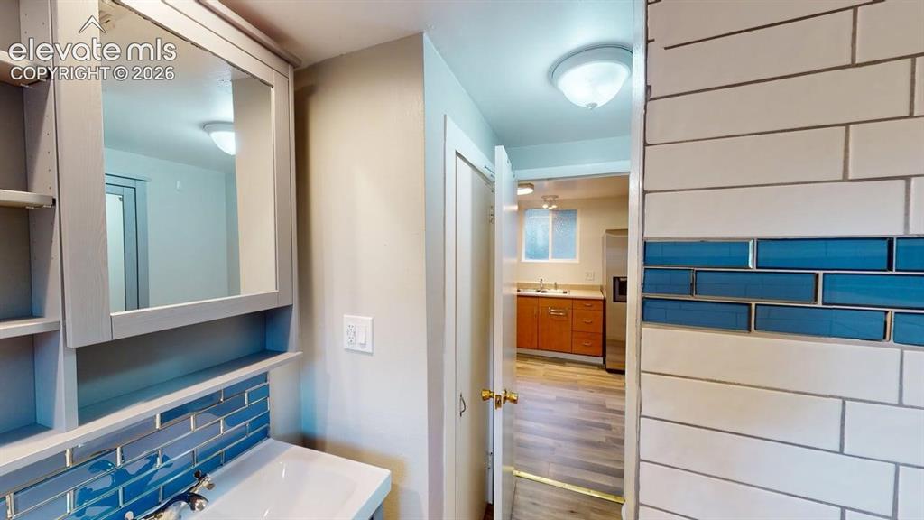 Image 22 of 49: Bathroom vanity featuring a built-in medicine cabinet, open shelving, and a