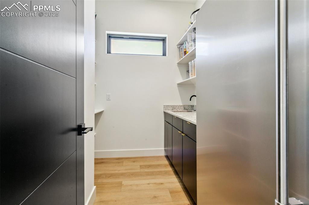 Image 18 of 50: Separate butler pantry with door; utility sink and shelving