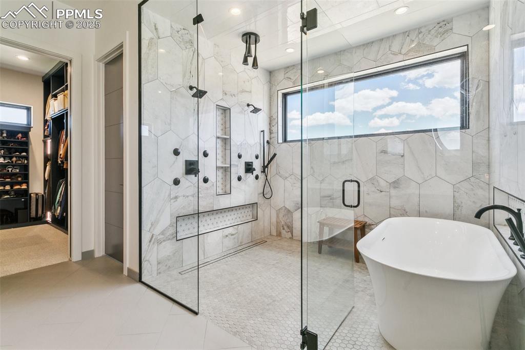 Image 27 of 50: Wet room with multiple shower heads; and two private toilet areas