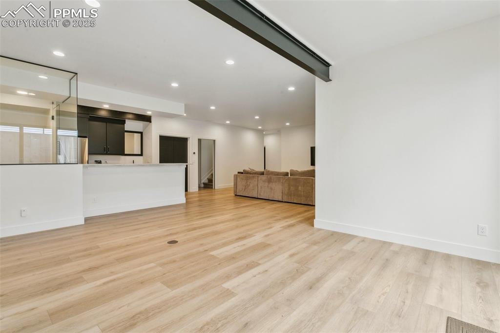 Image 34 of 50: Huge space in lower level with view of bar and glassed in area